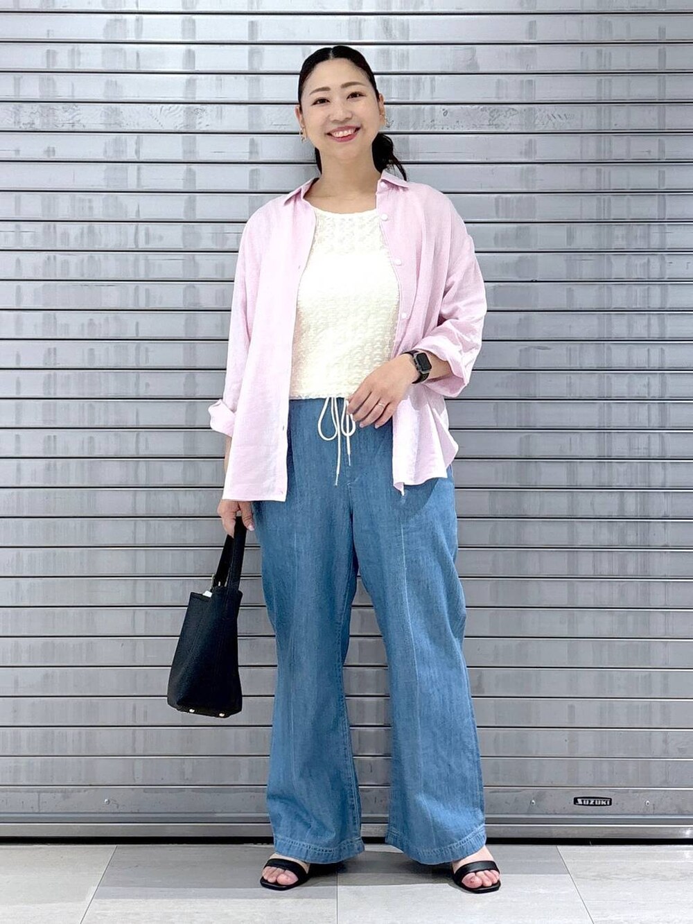 ブラック系のハンドバッグ、ピンク系のシャツ/ブラウス、ホワイト系のTシャツ/カットソーを着用したレディースの春コーディネートの2枚目の写真