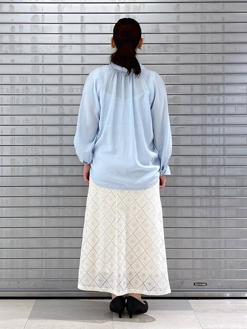 ブラック系のパンプス、ブラック系のハンドバッグ、ブルー系のシャツ/ブラウスを着用したレディースの春コーディネートの4枚目の写真