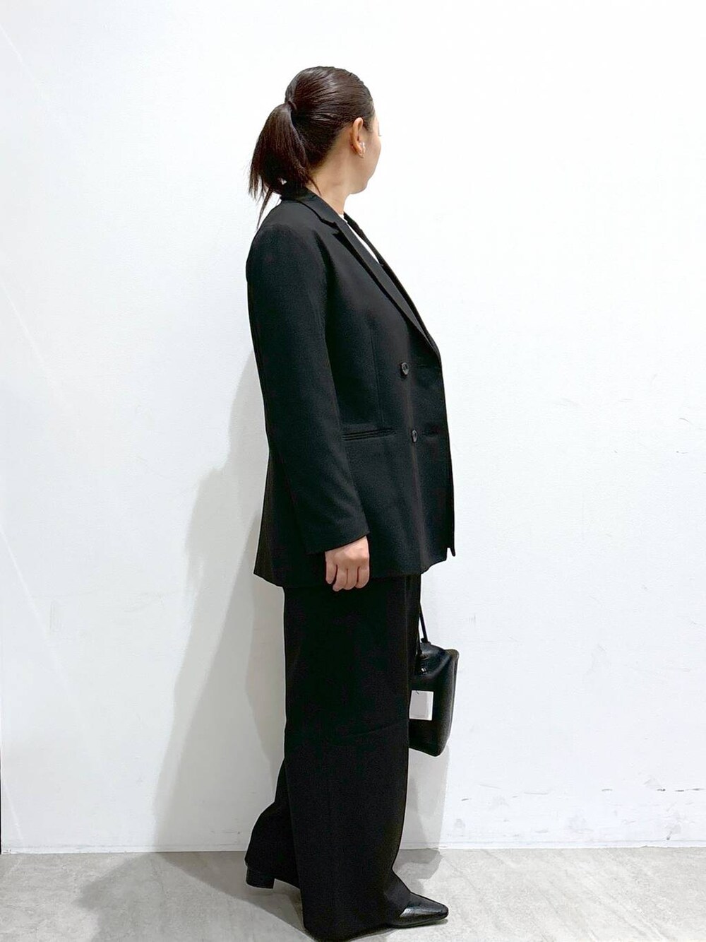 ホワイト系のシャツ/ブラウス、ブラック系のローファー、ブラック系のその他アウターを着用したレディースの秋コーディネートの5枚目の写真