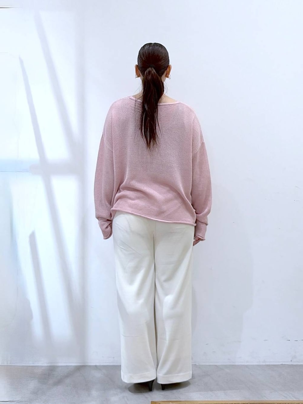 ブラック系のその他パンツ、ピンク系のニット/セーター、ブラック系のハンドバッグを着用したレディースの春コーディネートの4枚目の写真