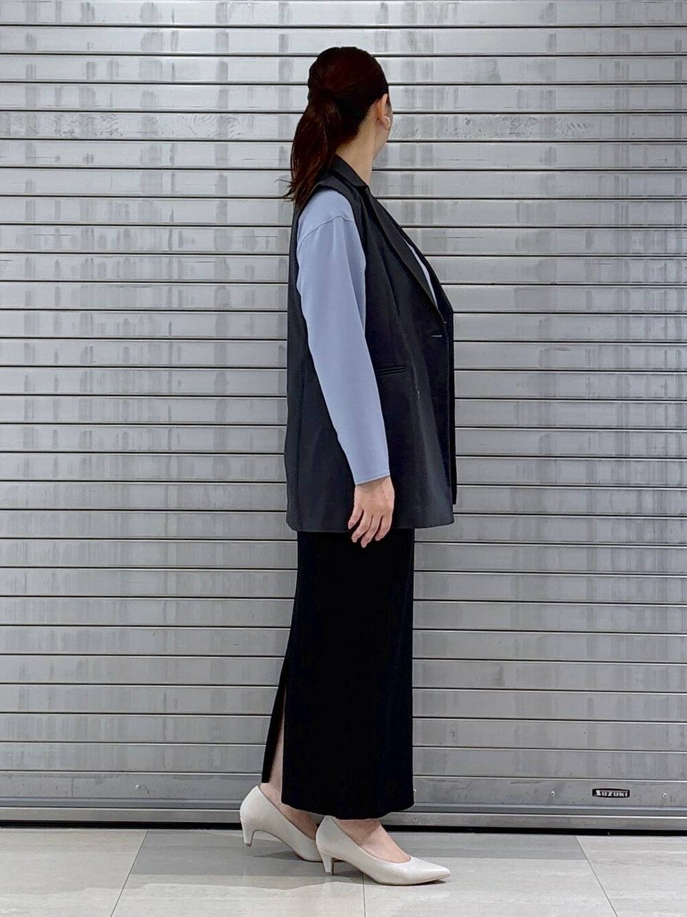 ベージュ系のハンドバッグ、グレー系のベスト、ブルー系のシャツ/ブラウスを着用したレディースの春コーディネートの5枚目の写真