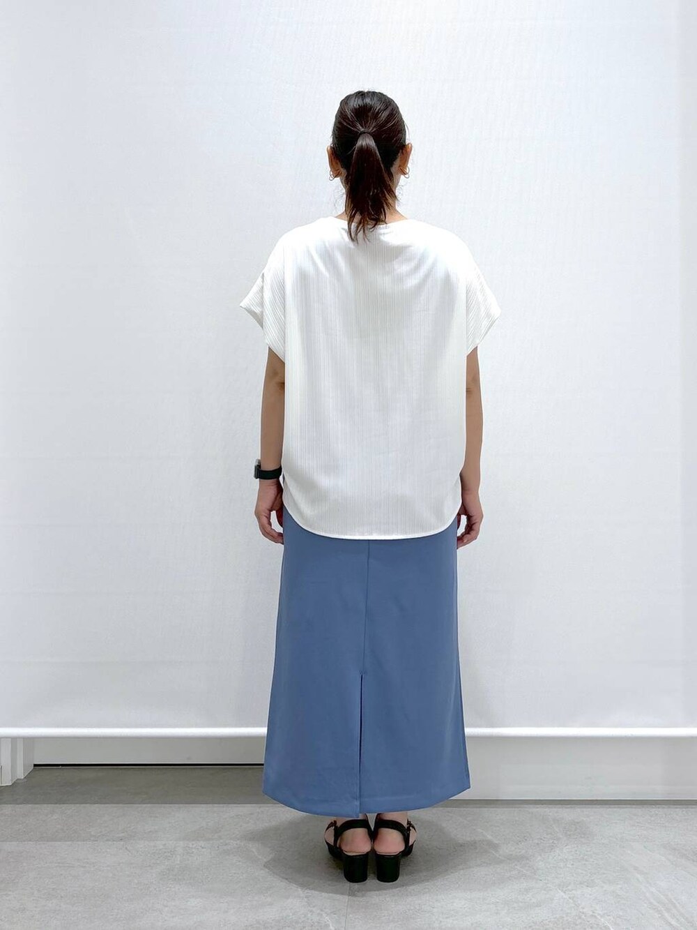 ホワイト系のTシャツ/カットソー、ブラック系のサンダル、ブルー系のスカートを着用したレディースの夏コーディネートの5枚目の写真