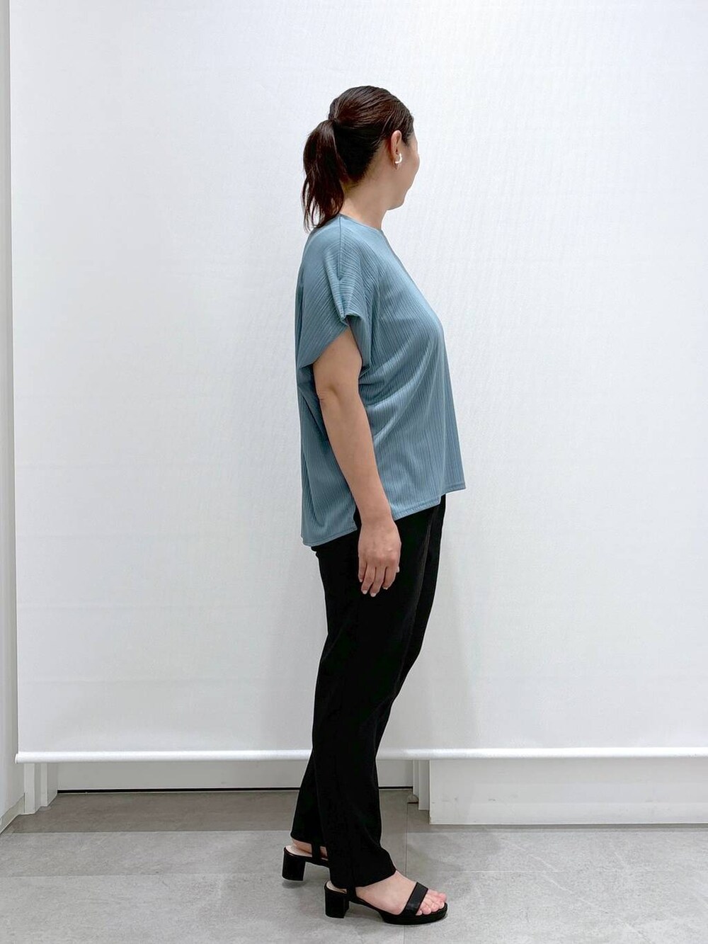 ゴールド系のトートバッグ、ブラック系のその他パンツ、グリーン系のTシャツ/カットソーを着用したレディースの秋コーディネートの5枚目の写真
