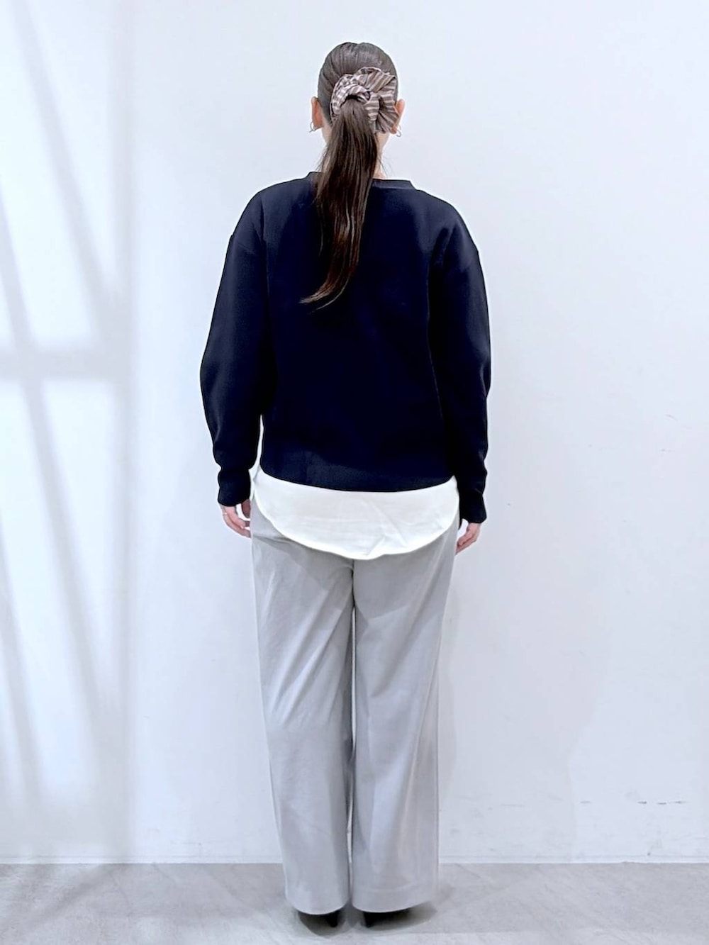 ブラック系のハンドバッグ、グレー系のその他パンツ、ブルー系のカーディガン/ボレロを着用したレディースの春コーディネートの4枚目の写真