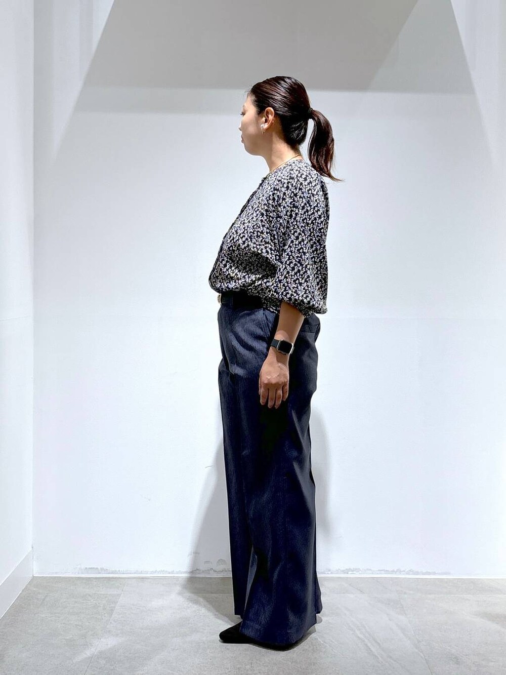 ブラック系のトートバッグ、ブラック系のパンプス、ブルー系のデニムパンツを着用したレディースの秋コーディネートの3枚目の写真