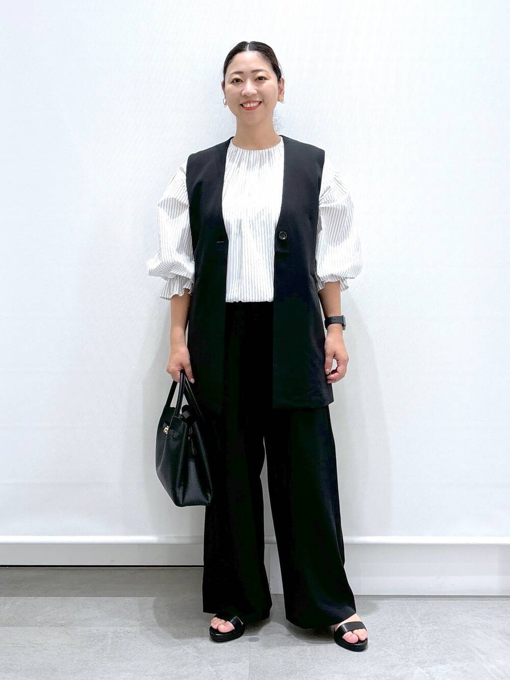 ホワイト系のシャツ/ブラウス、ブラック系のサンダル、ブラック系のその他パンツを着用したレディースの夏コーディネートの2枚目の写真