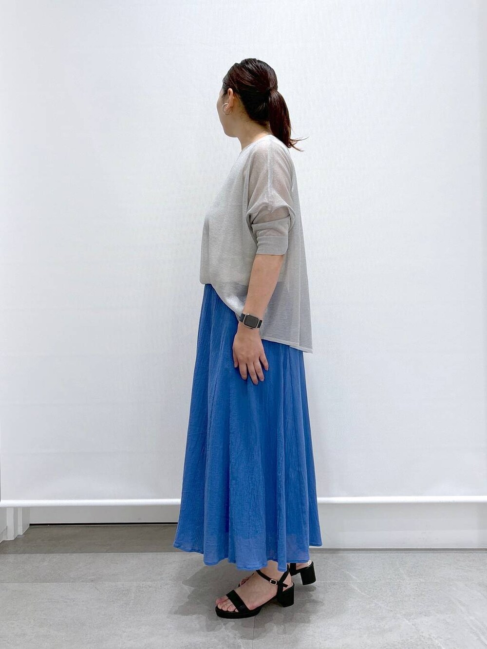 ブラック系のトートバッグ、グレー系のニット/セーター、ホワイト系のタンクトップを着用したレディースの夏コーディネートの3枚目の写真