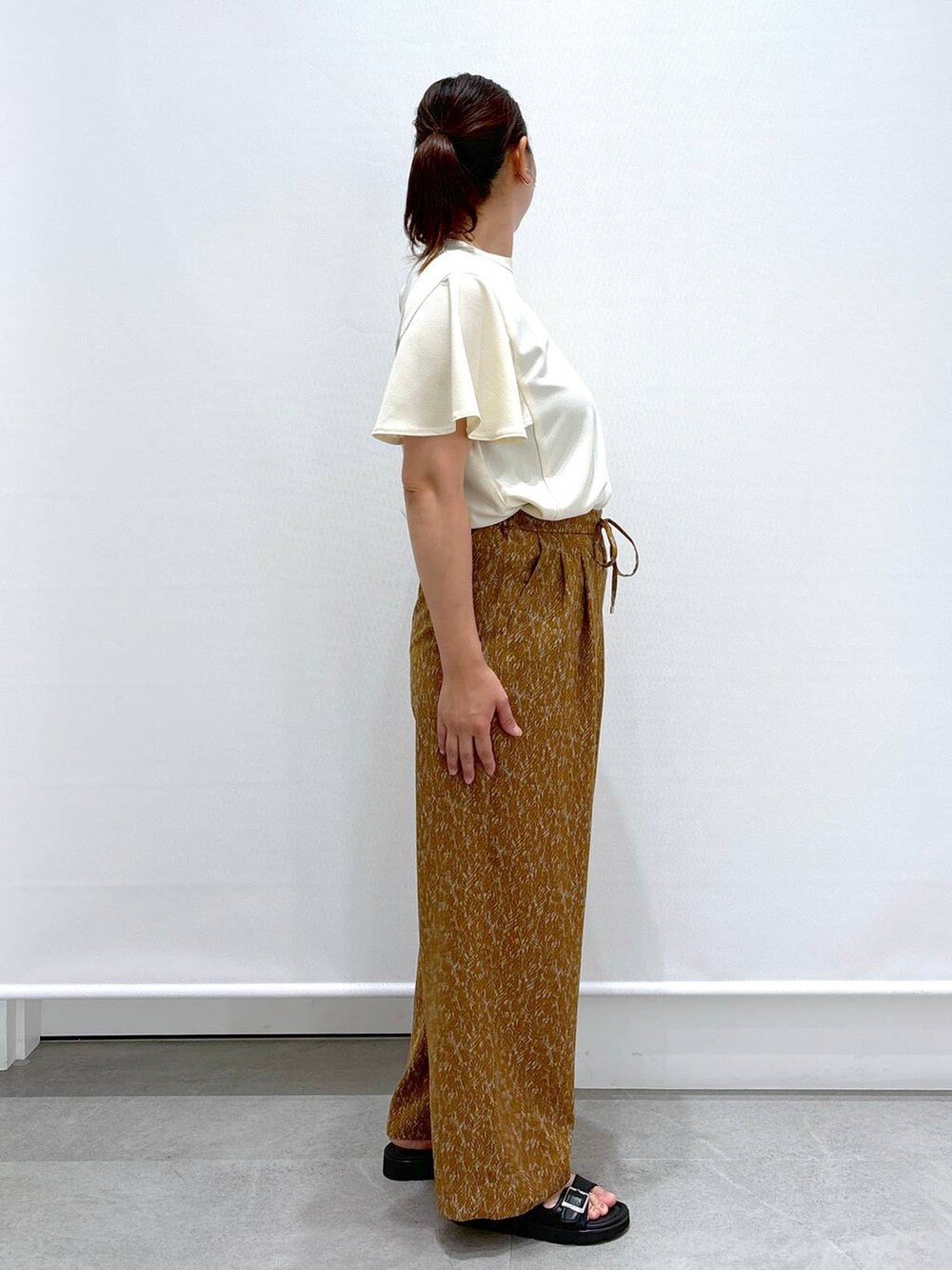 ブラック系のハンドバッグ、ホワイト系のシャツ/ブラウス、ブラウン系のその他パンツを着用したレディースの夏コーディネートの5枚目の写真