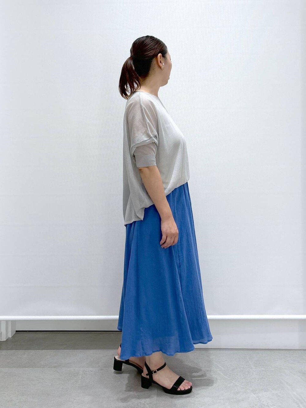 ブラック系のトートバッグ、グレー系のニット/セーター、ホワイト系のタンクトップを着用したレディースの夏コーディネートの5枚目の写真