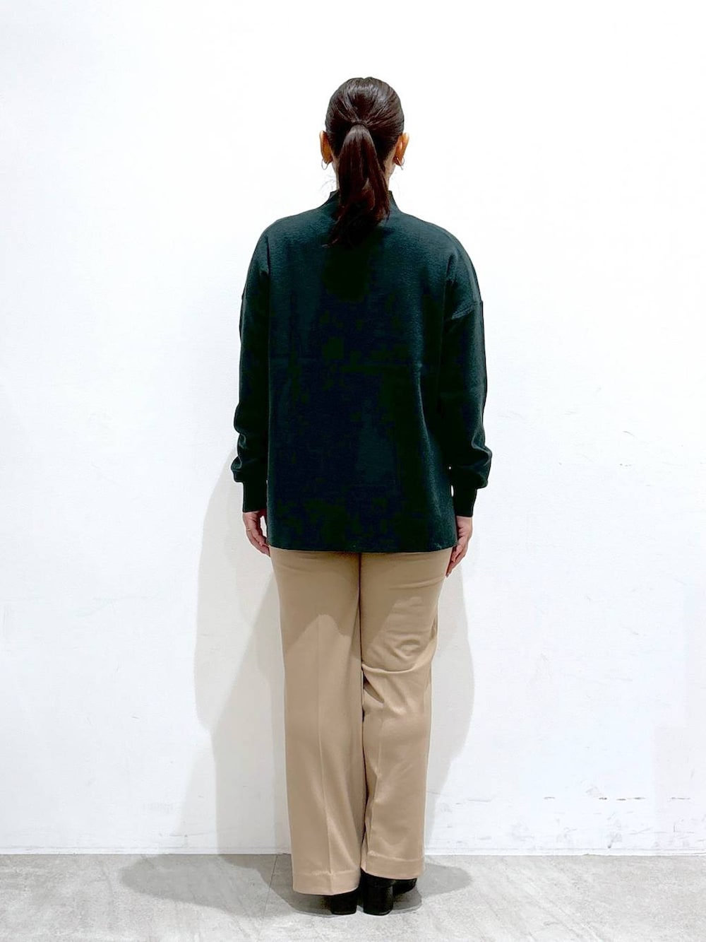 ホワイト系のシャツ/ブラウス、ブラック系のブーツ、グリーン系のニット/セーターを着用したレディースの秋コーディネートの4枚目の写真