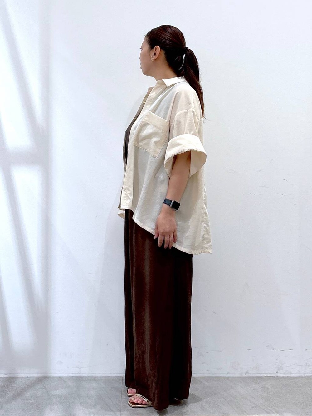ブラウン系のその他パンツ、ゴールド系のサンダル、ホワイト系のシャツ/ブラウスを着用したレディースの夏コーディネートの3枚目の写真