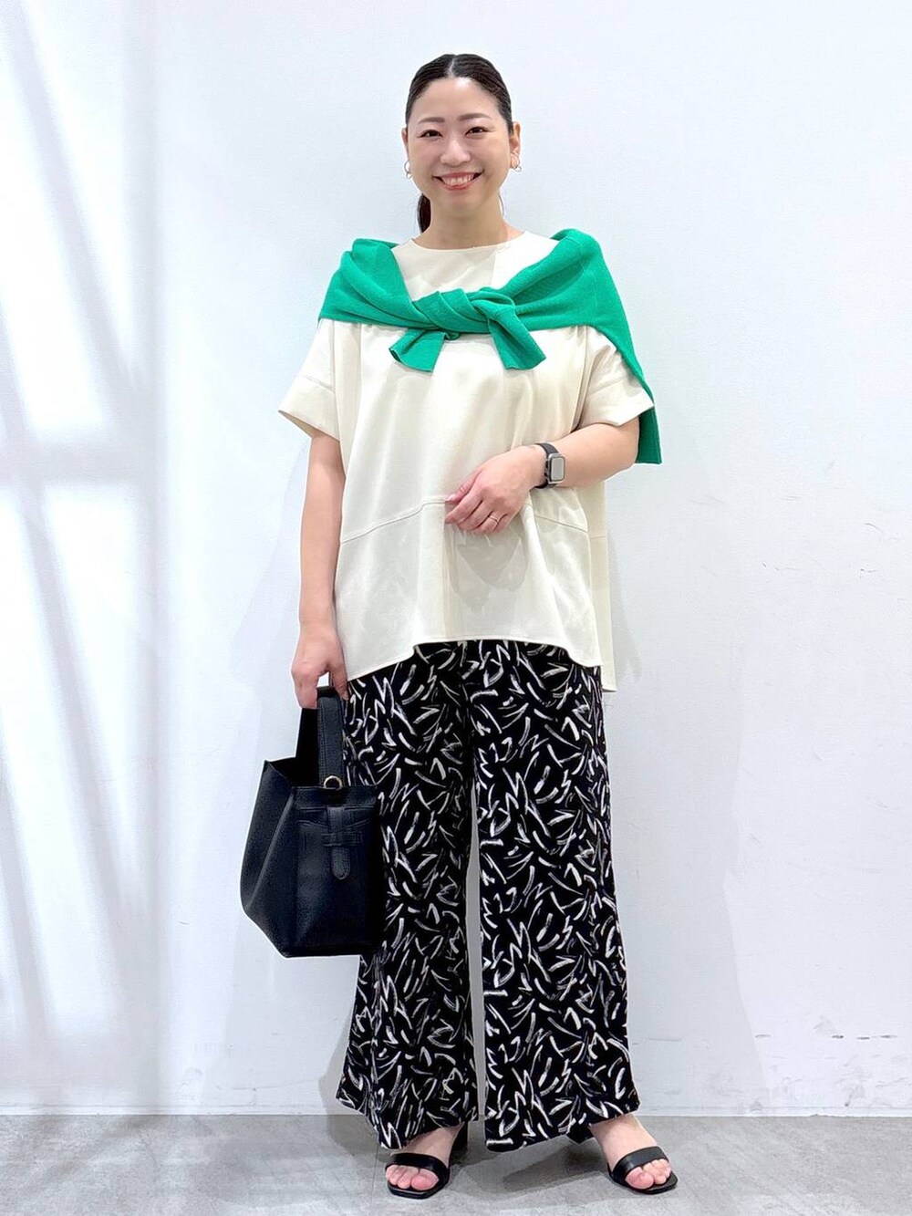 ブラック系のその他パンツ、ホワイト系のシャツ/ブラウス、ブラック系のハンドバッグを着用したレディースの春コーディネートの2枚目の写真