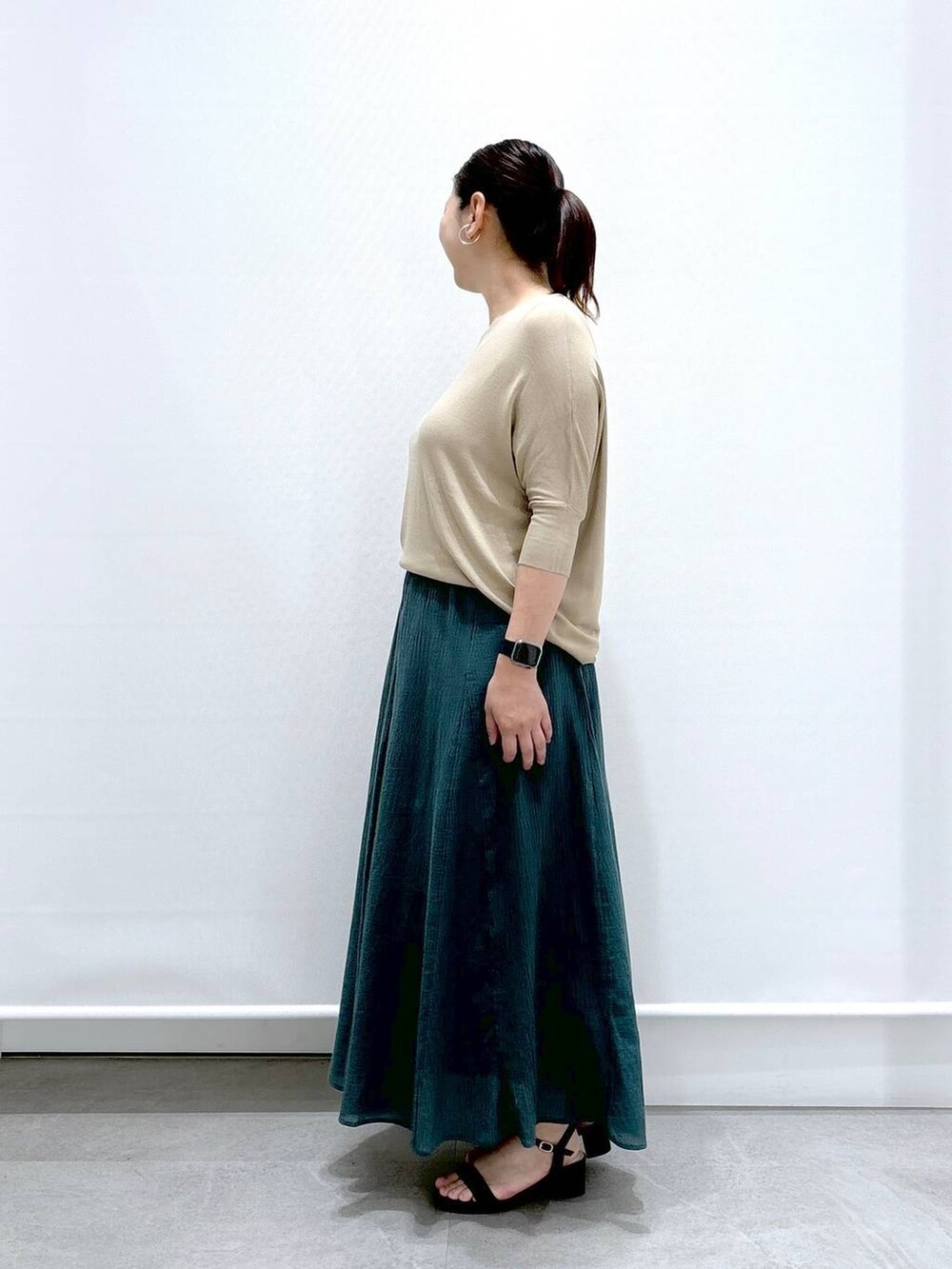 ブラック系のトートバッグ、ブラック系のサンダル、グリーン系のスカートを着用したレディースの夏コーディネートの3枚目の写真