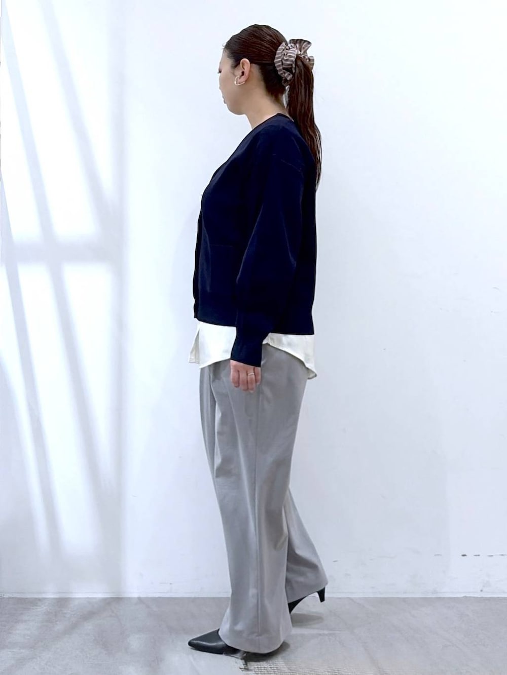 ブラック系のハンドバッグ、グレー系のその他パンツ、ブルー系のカーディガン/ボレロを着用したレディースの春コーディネートの3枚目の写真