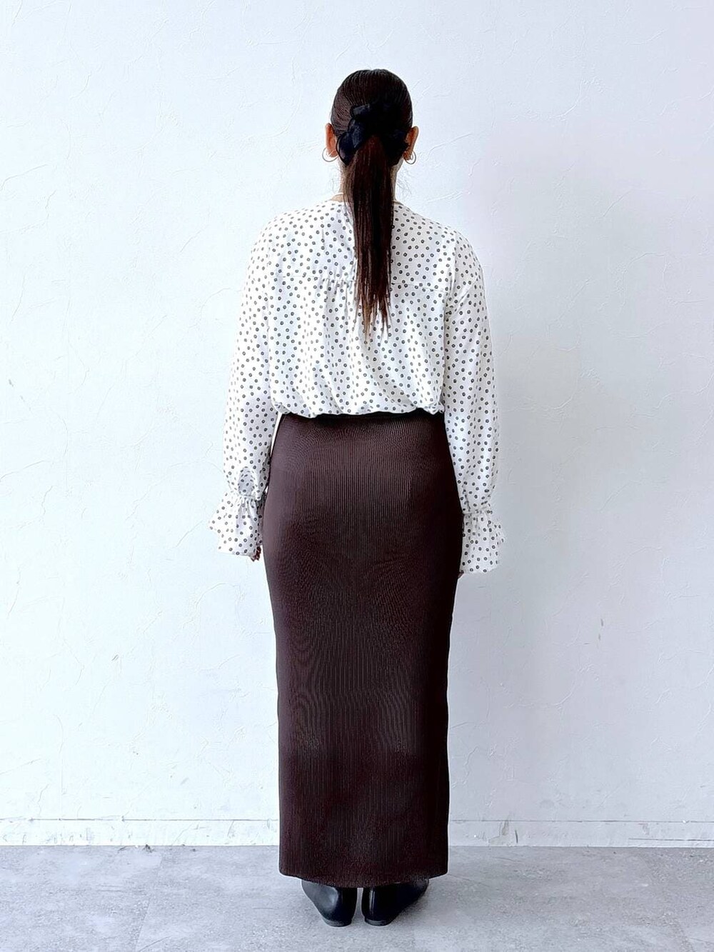 ブラック系のパンプス、ブラック系のトートバッグ、ホワイト系のシャツ/ブラウスを着用したレディースの冬コーディネートの4枚目の写真