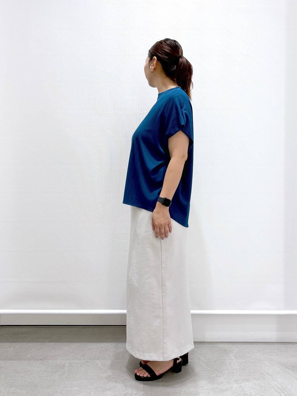 ブルー系のTシャツ/カットソー、グレー系のスカート、ブラック系のトートバッグを着用したレディースの夏コーディネートの3枚目の写真