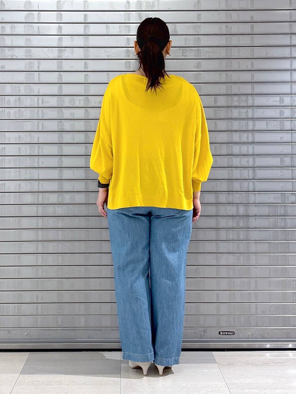 ホワイト系のハンドバッグ、イエロー系のニット/セーターを着用したレディースの春コーディネートの4枚目の写真