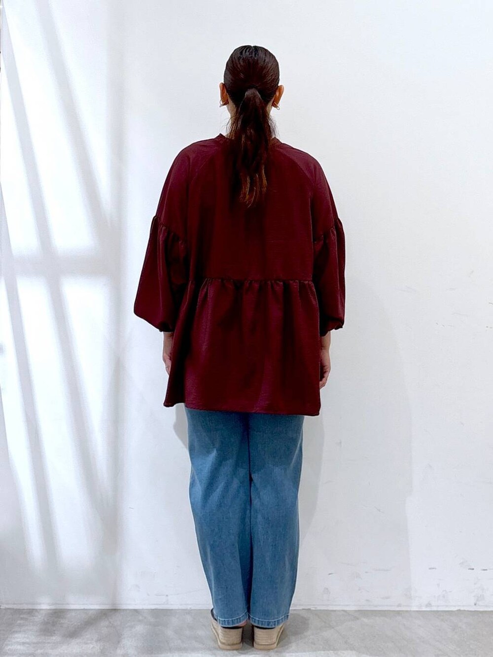 ブラック系のハンドバッグ、ブラック系のサンダル、ブルー系のデニムパンツを着用したレディースの夏コーディネートの3枚目の写真