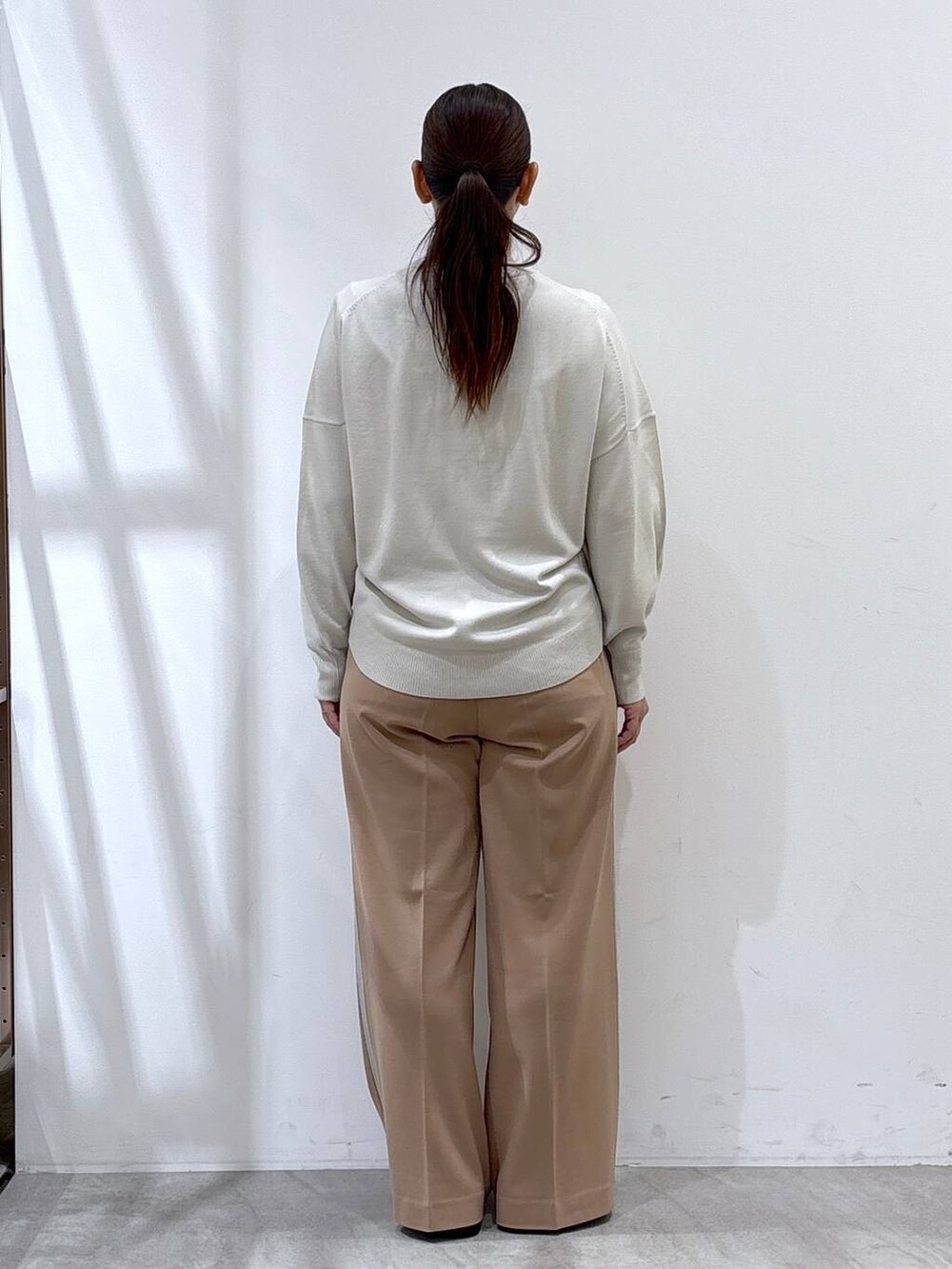 ベージュ系のTシャツ/カットソー、ブラック系のハンドバッグ、ブルー系のテーラードジャケットを着用したレディースの秋コーディネートの3枚目の写真