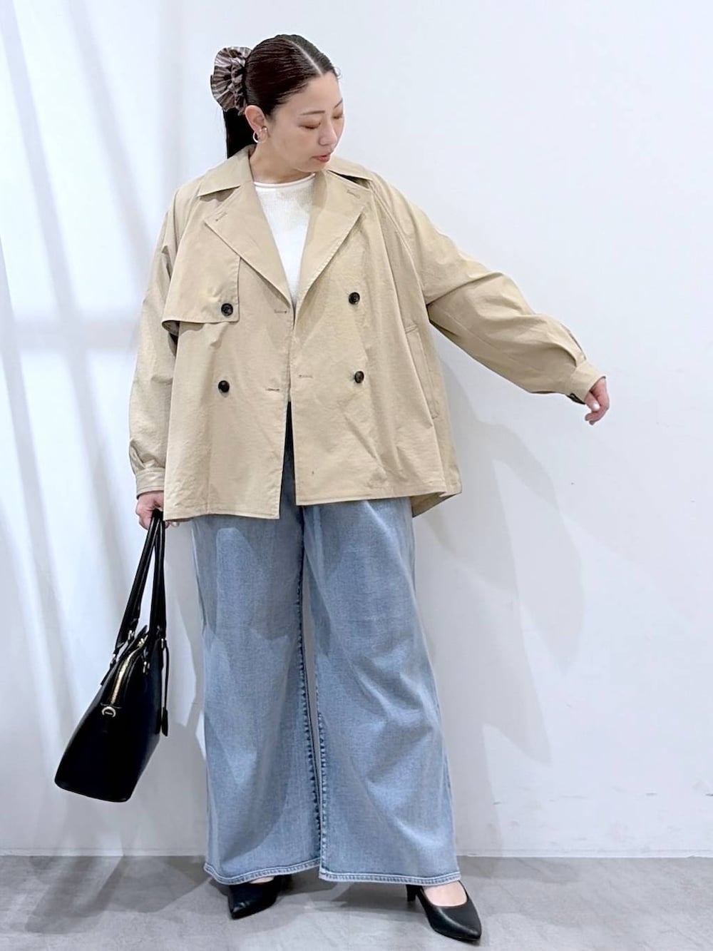 ホワイト系のニット/セーター、ブルー系のデニムパンツ、ブラック系のハンドバッグを着用したレディースの春コーディネートの7枚目の写真