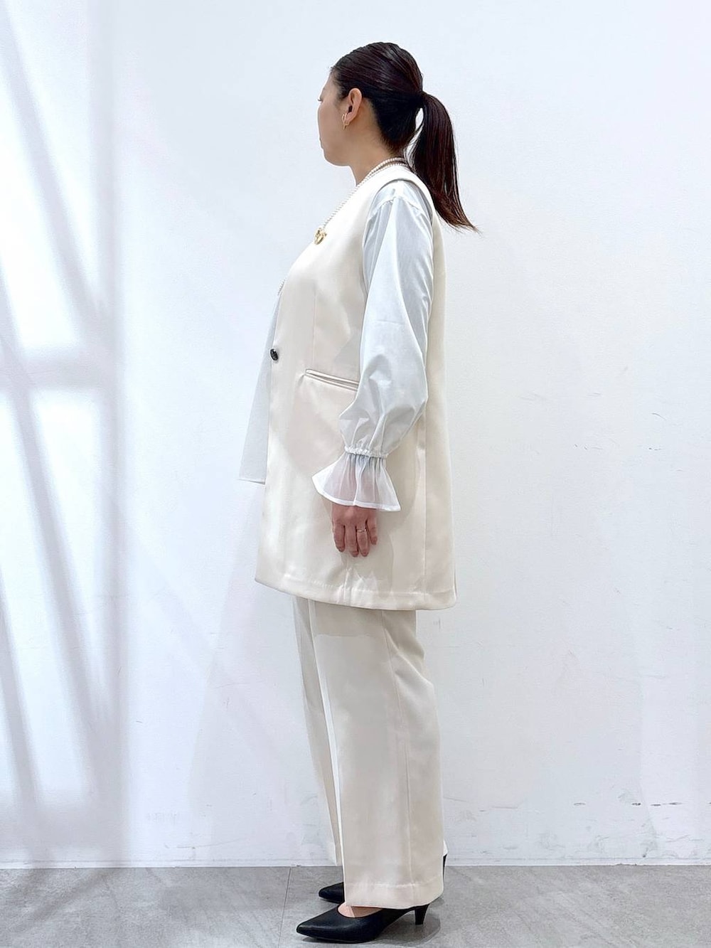 ホワイト系のその他パンツ、ホワイト系のスーツベスト、ホワイト系のシャツ/ブラウスを着用したレディースの冬コーディネートの3枚目の写真