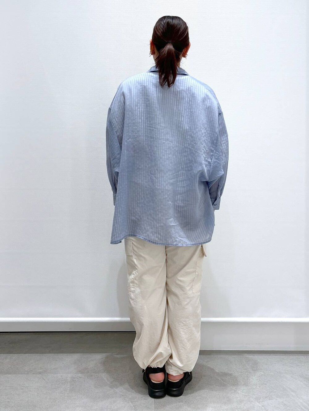 ホワイト系のTシャツ/カットソー、ブラック系のサンダル、ブラック系のハンドバッグを着用したレディースの春コーディネートの4枚目の写真