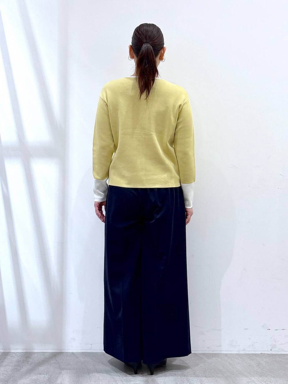 ブラック系のハンドバッグ、ブルー系のその他パンツ、イエロー系のカーディガン/ボレロを着用したレディースの春コーディネートの4枚目の写真