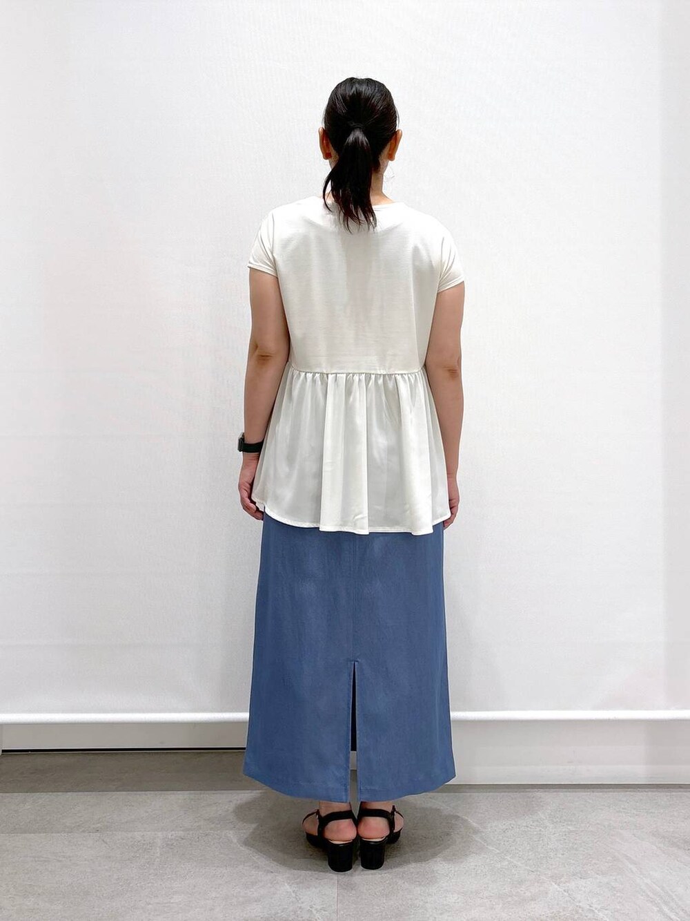 ブラック系のトートバッグ、ブラック系のサンダル、ブルー系のデニムスカートを着用したレディースの夏コーディネートの4枚目の写真