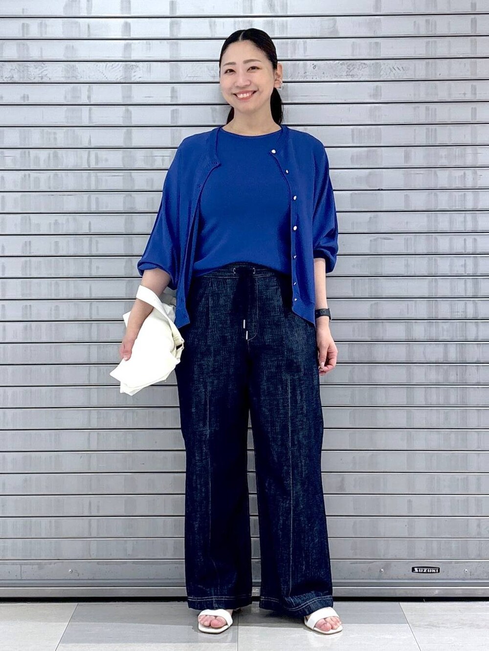 ブルー系のカーディガン/ボレロ、ブルー系のニット/セーター、ブルー系のデニムパンツを着用したレディースの春コーディネートの2枚目の写真