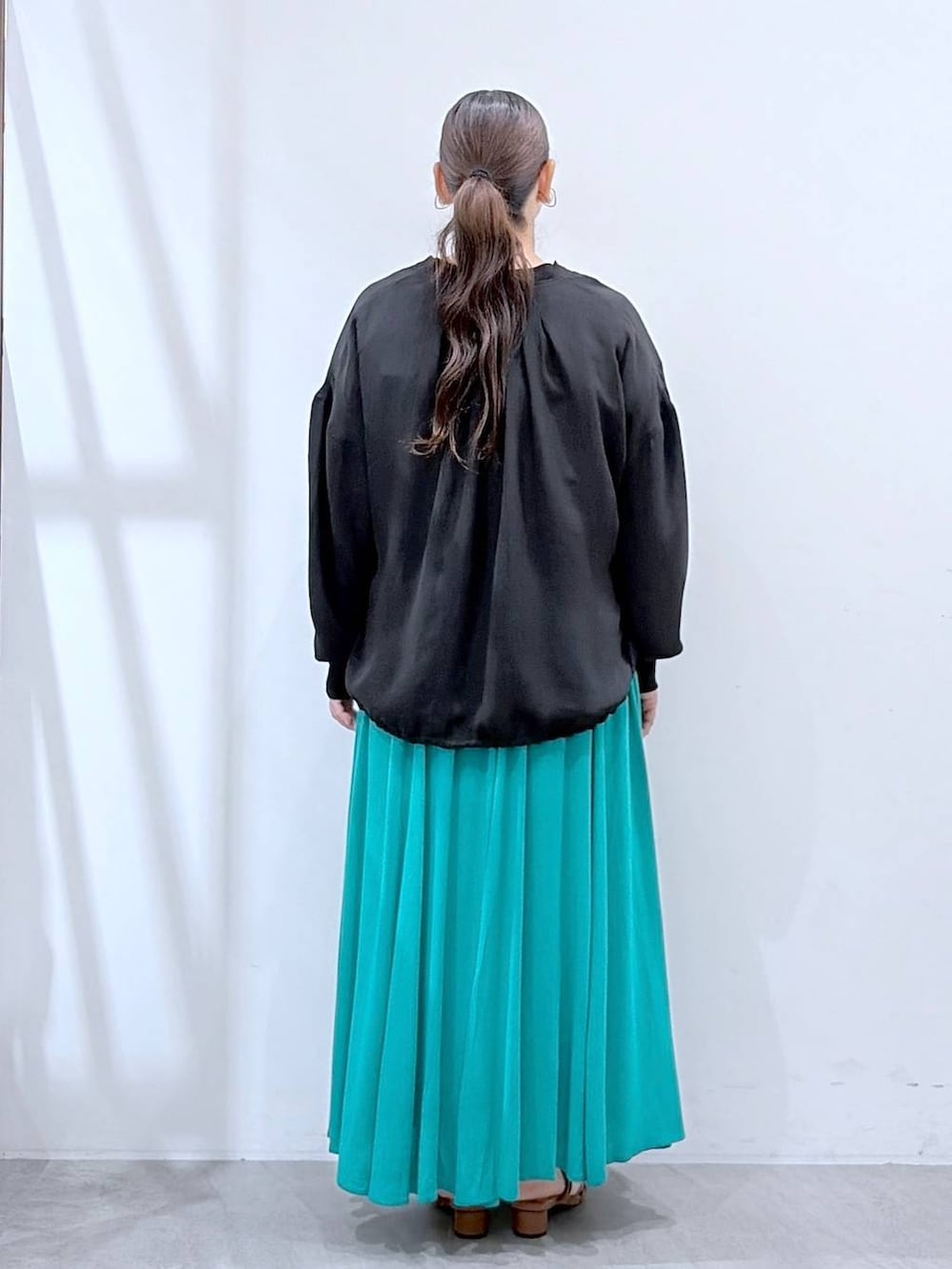ブラウン系のサンダル、ブラウン系のハンドバッグ、ホワイト系のTシャツ/カットソーを着用したレディースの夏コーディネートの4枚目の写真