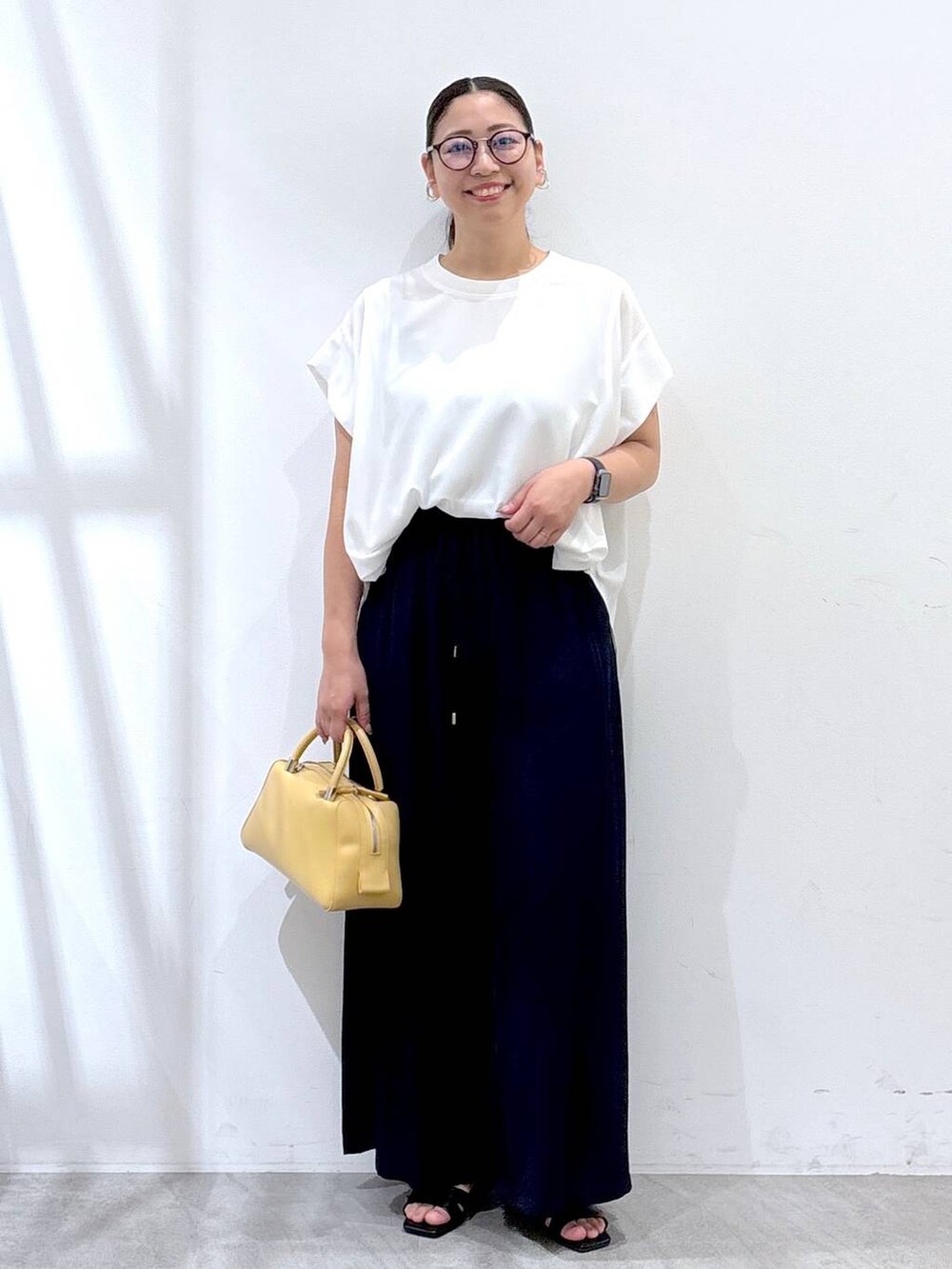 ブルー系のその他パンツ、ブラック系のサンダル、ホワイト系のTシャツ/カットソーを着用したレディースの夏コーディネートの2枚目の写真