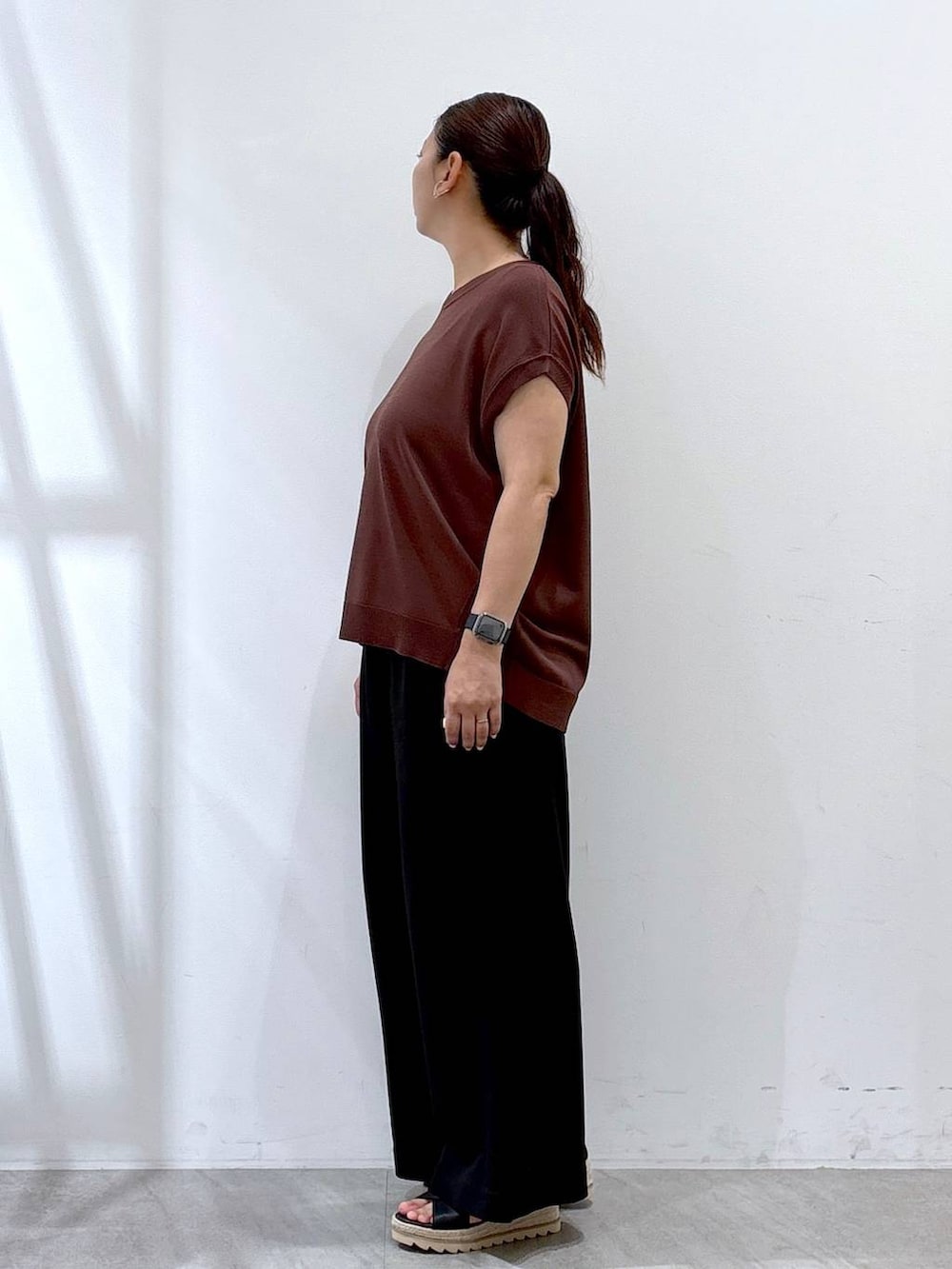 ブラック系のその他パンツ、ブラック系のハンドバッグ、ブラウン系のニット/セーターを着用したレディースの夏コーディネートの3枚目の写真