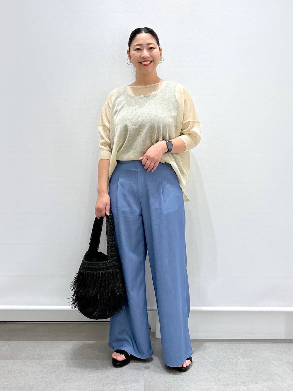 ブルー系のデニムパンツ、ベージュ系のニット/セーター、ブルー系のデニムパンツを着用したレディースの夏コーディネートの2枚目の写真