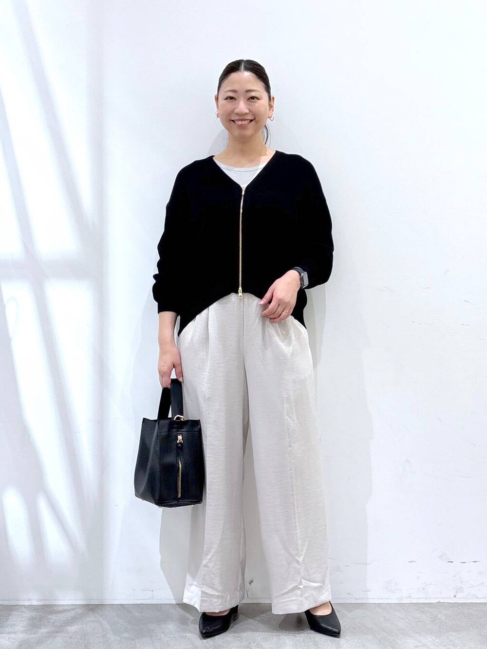 ホワイト系のTシャツ/カットソー、ベージュ系のその他パンツ、ブラック系のカーディガン/ボレロを着用したレディースの春コーディネートの2枚目の写真