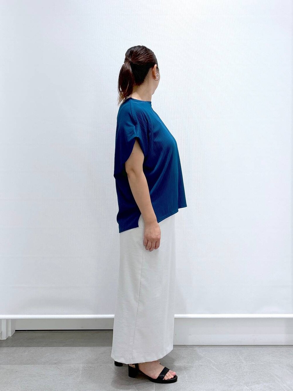 ブルー系のTシャツ/カットソー、グレー系のスカート、ブラック系のトートバッグを着用したレディースの夏コーディネートの5枚目の写真