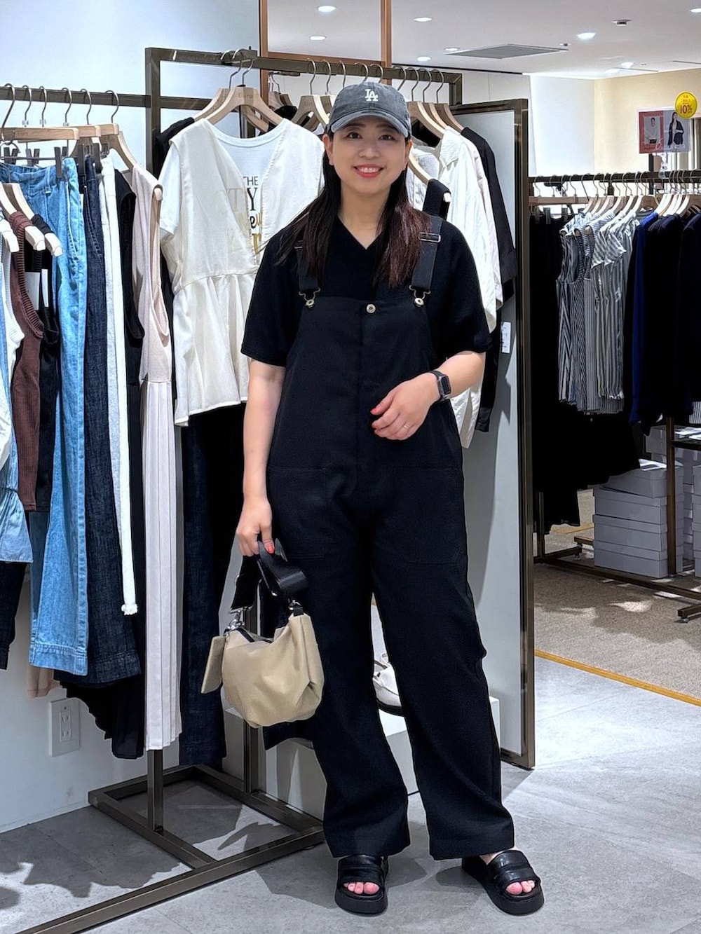 ブラック系のサンダル、ブラック系のニット/セーター、ブラック系のサロペット/オーバーオールを着用したレディースの春コーディネートの2枚目の写真