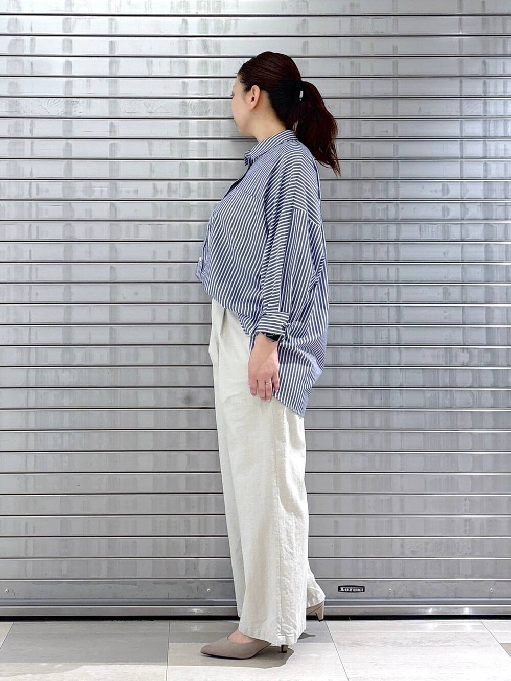 ベージュ系のパンプス、ベージュ系のハンドバッグ、イエロー系のニット/セーターを着用したレディースの春コーディネートの2枚目の写真