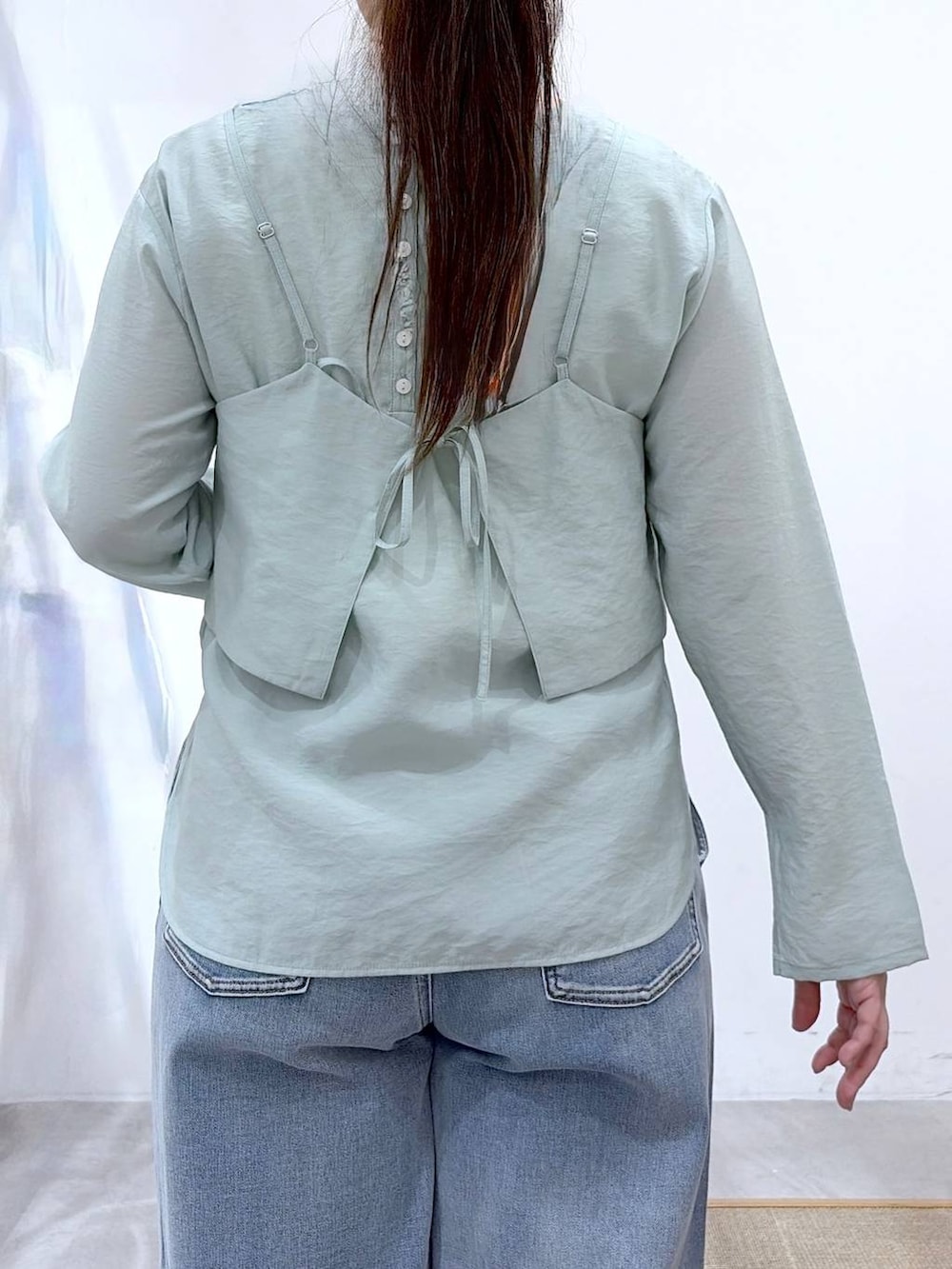 ブルー系のデニムパンツ、ブラック系のハンドバッグ、グリーン系のシャツ/ブラウスを着用したレディースの春コーディネートの7枚目の写真