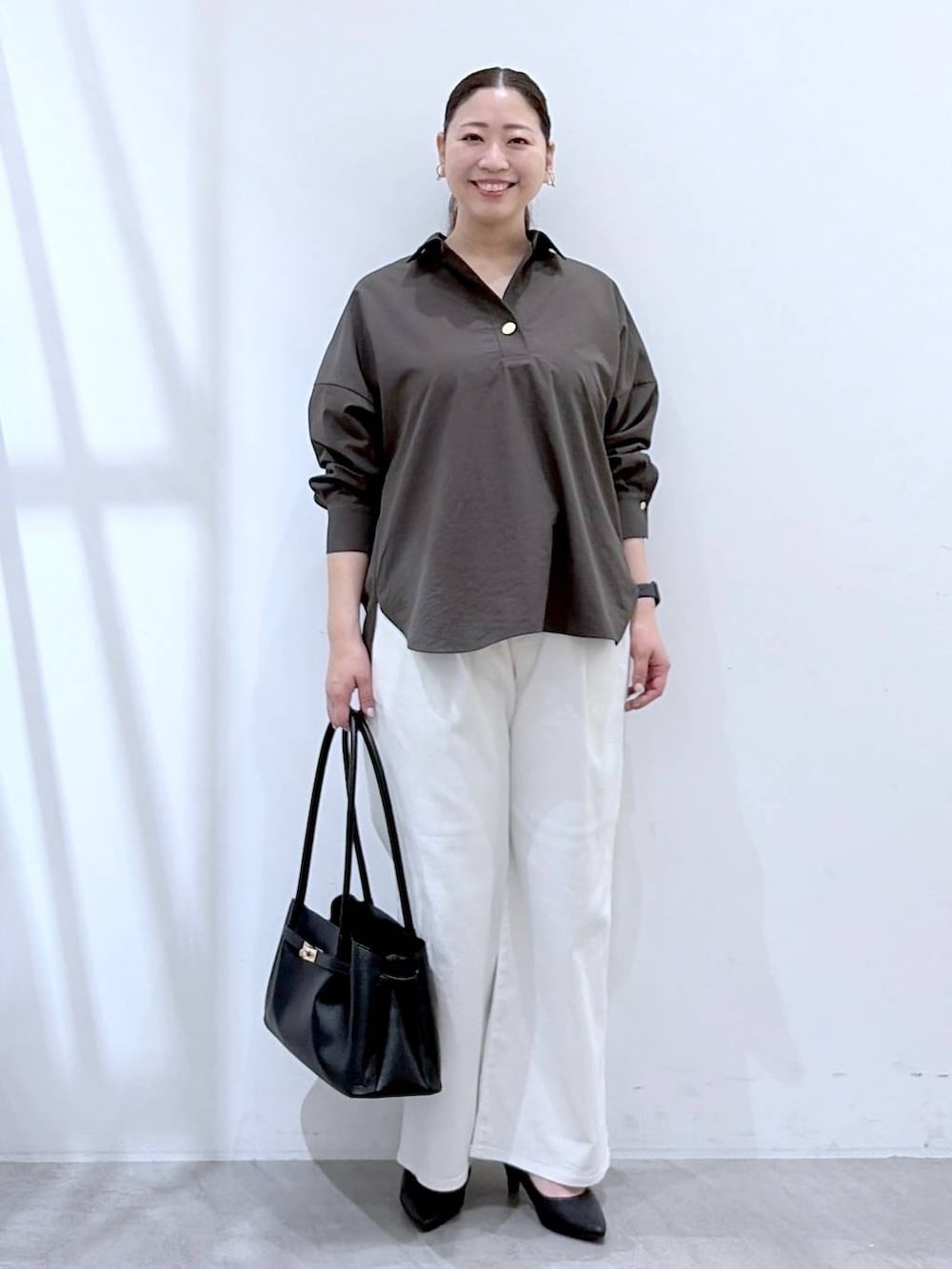 ホワイト系のデニムパンツ、ブラック系のハンドバッグ、ブラウン系のシャツ/ブラウスを着用したレディースの春コーディネートの2枚目の写真