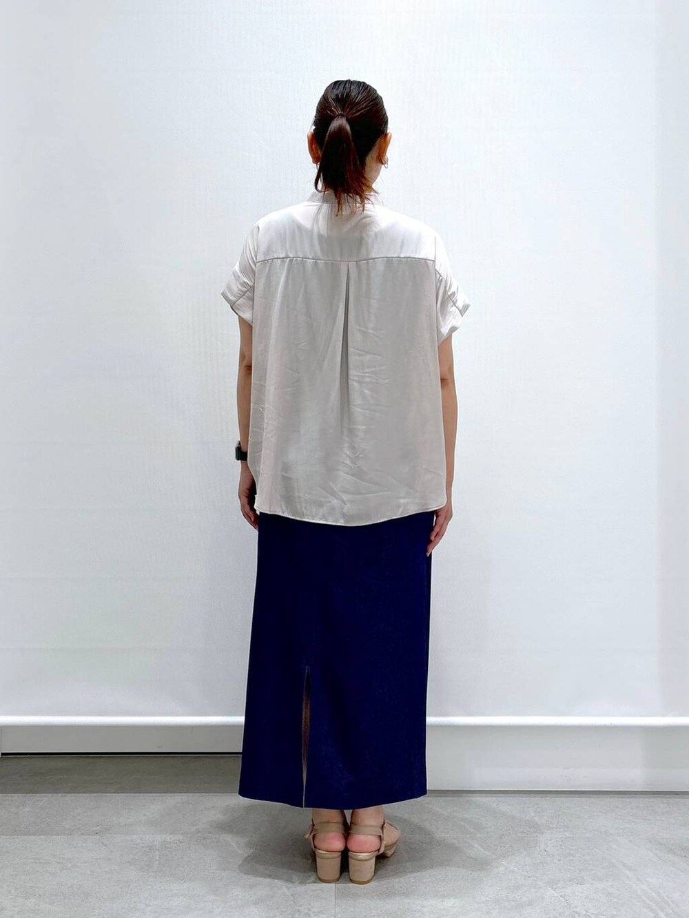 ベージュ系のシャツ/ブラウス、ベージュ系のサンダル、ブルー系のデニムスカートを着用したレディースの夏コーディネートの4枚目の写真