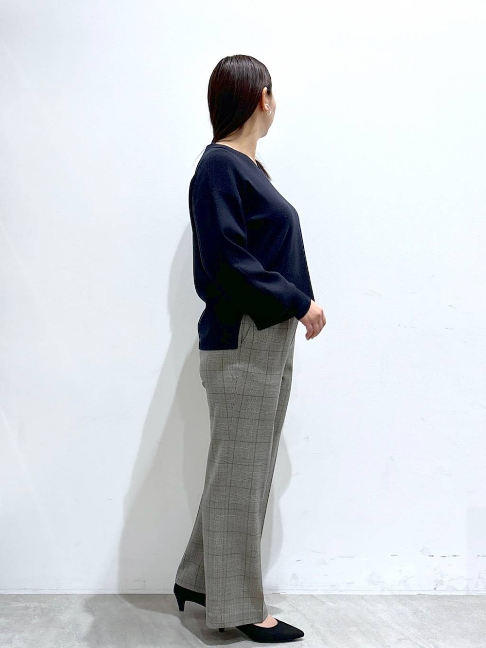 ブラック系のトートバッグ、ブルー系のニット/セーター、ブラック系のパンプスを着用したレディースの冬コーディネートの5枚目の写真