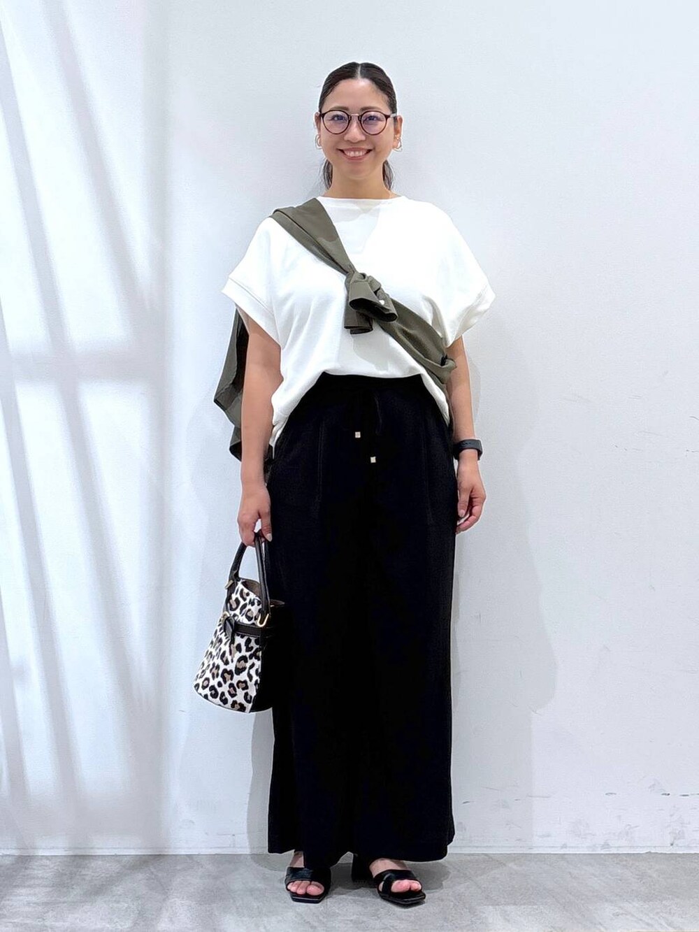 ブラック系のその他パンツ、ブラック系のサンダル、ホワイト系のTシャツ/カットソーを着用したレディースの秋コーディネートの2枚目の写真