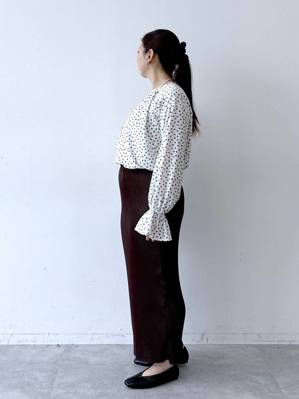 ブラック系のパンプス、ブラック系のトートバッグ、ホワイト系のシャツ/ブラウスを着用したレディースの冬コーディネートの3枚目の写真