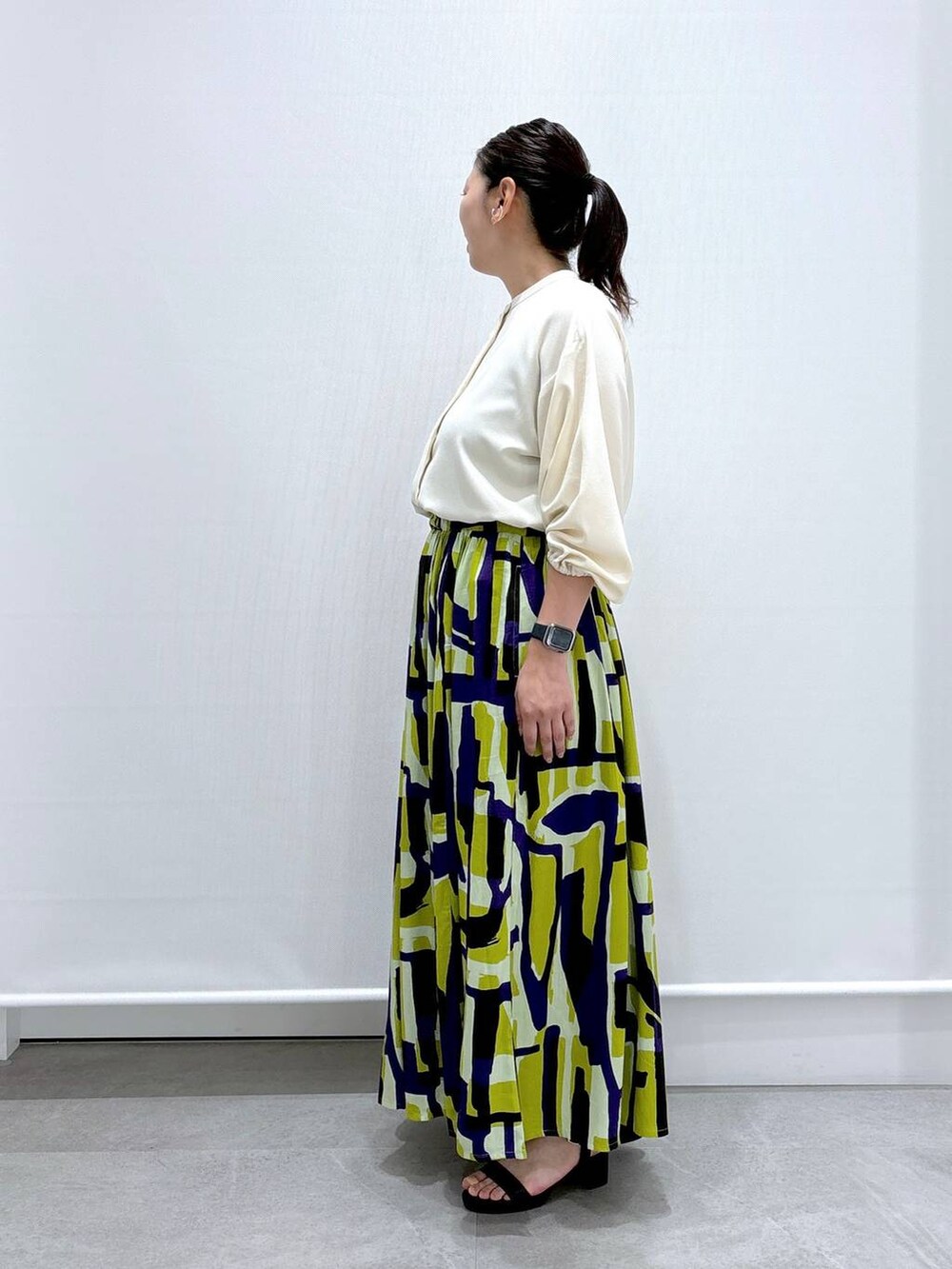 ブラック系のショルダーバッグ、ブラック系のサンダル、ホワイト系のシャツ/ブラウスを着用したレディースの夏コーディネートの3枚目の写真