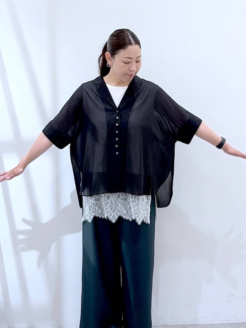 ブラック系のシャツ/ブラウス、グリーン系のその他パンツ、ホワイト系のかごバッグを着用したレディースの夏コーディネートの6枚目の写真