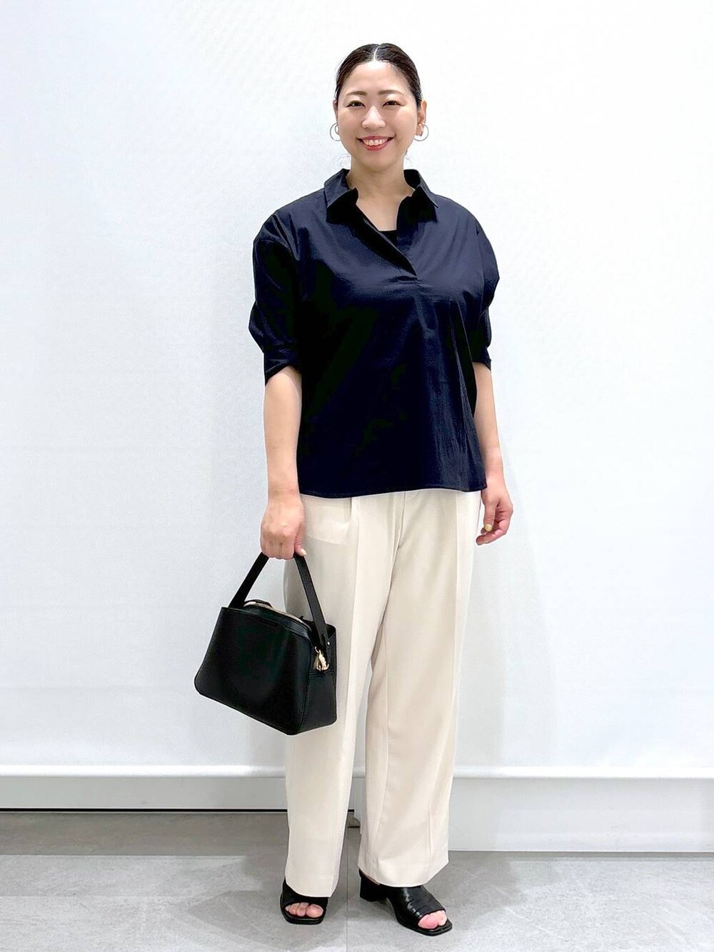 ホワイト系のその他パンツ、ブラック系のサンダル、ブラック系のハンドバッグを着用したレディースの春コーディネートの2枚目の写真