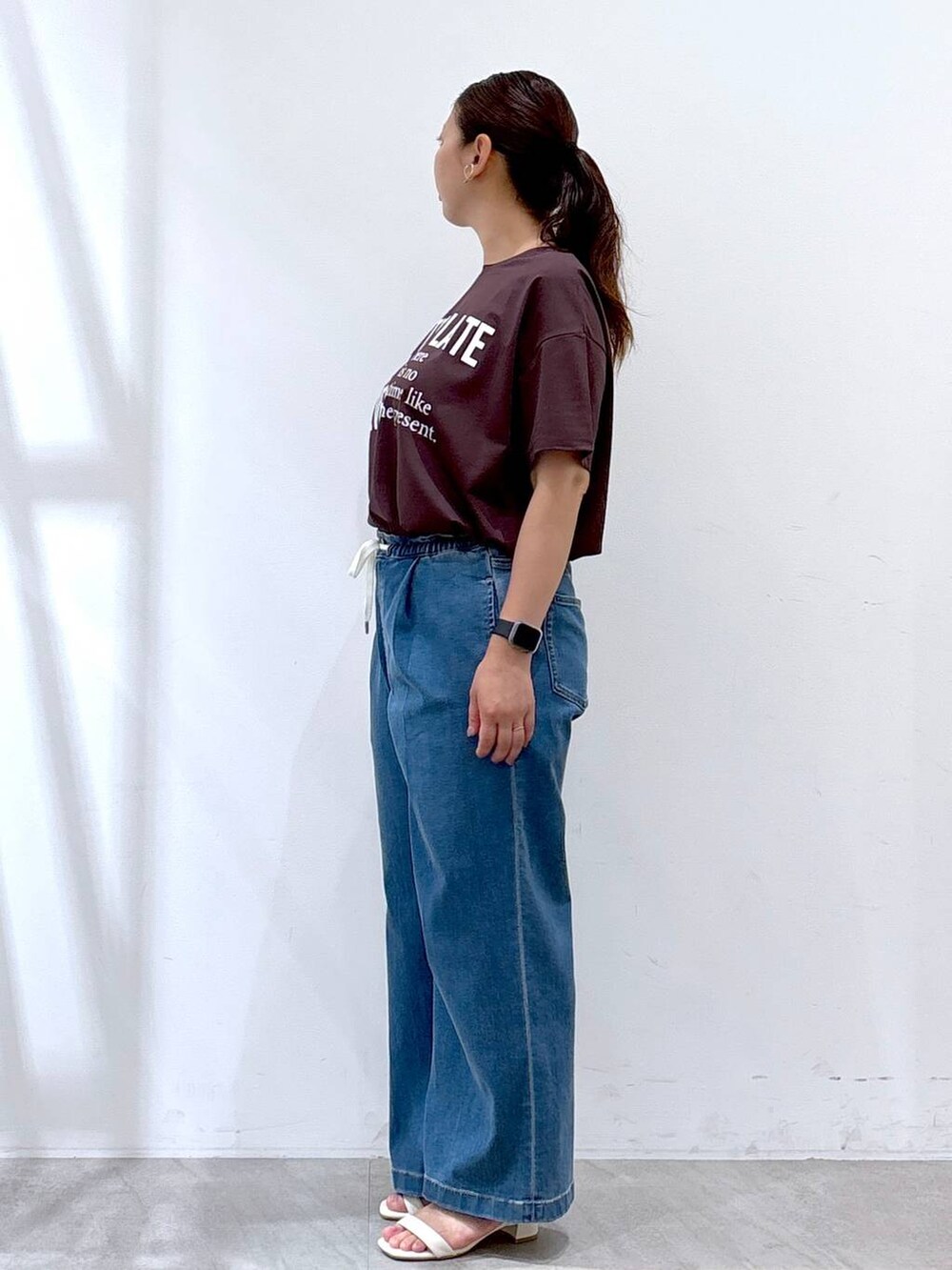 ホワイト系のトートバッグ、ブルー系のデニムパンツ、ブラウン系のTシャツ/カットソーを着用したレディースの夏コーディネートの3枚目の写真