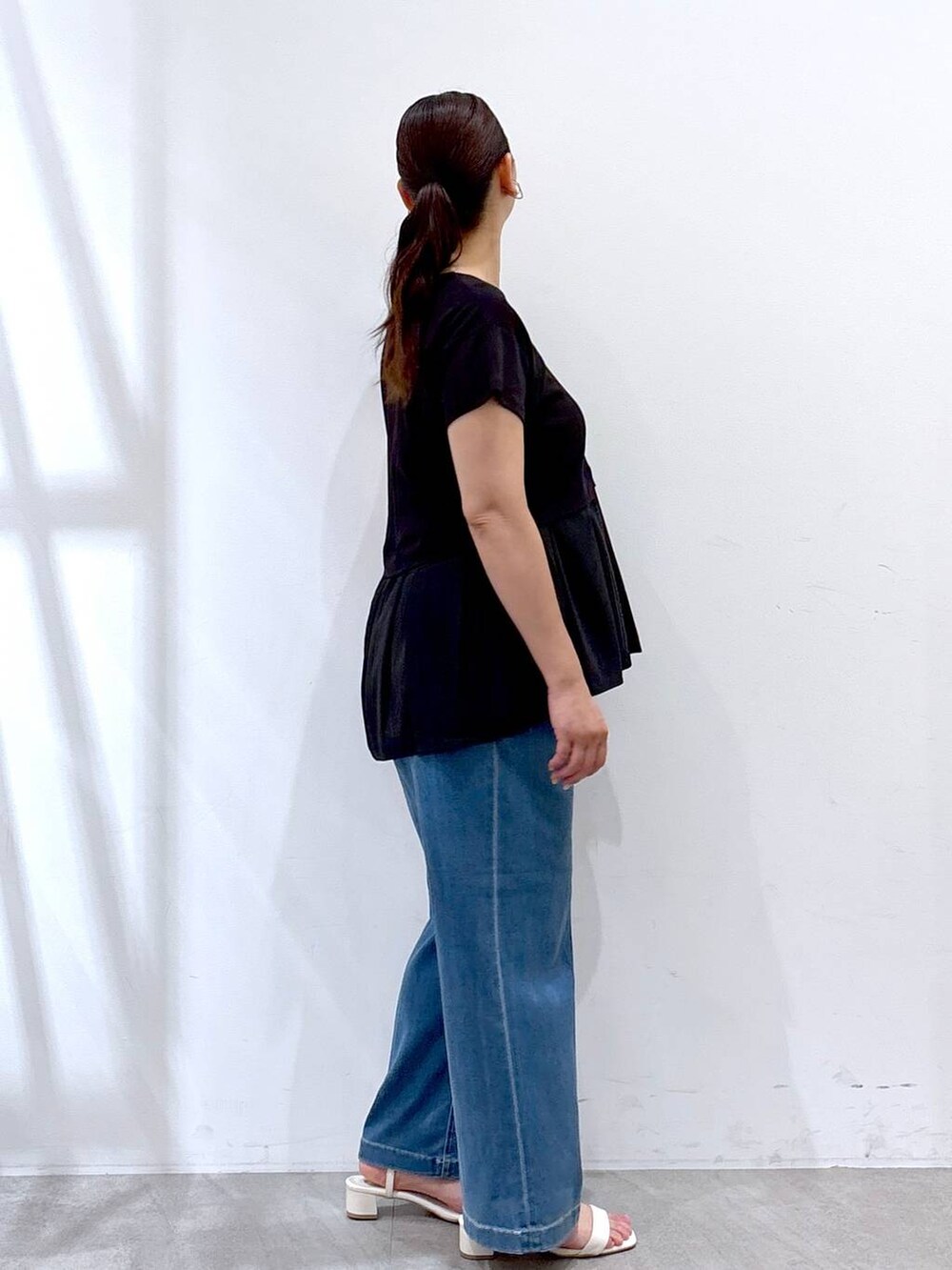 ブラック系のTシャツ/カットソー、ブルー系のデニムパンツを着用したレディースの夏コーディネートの5枚目の写真