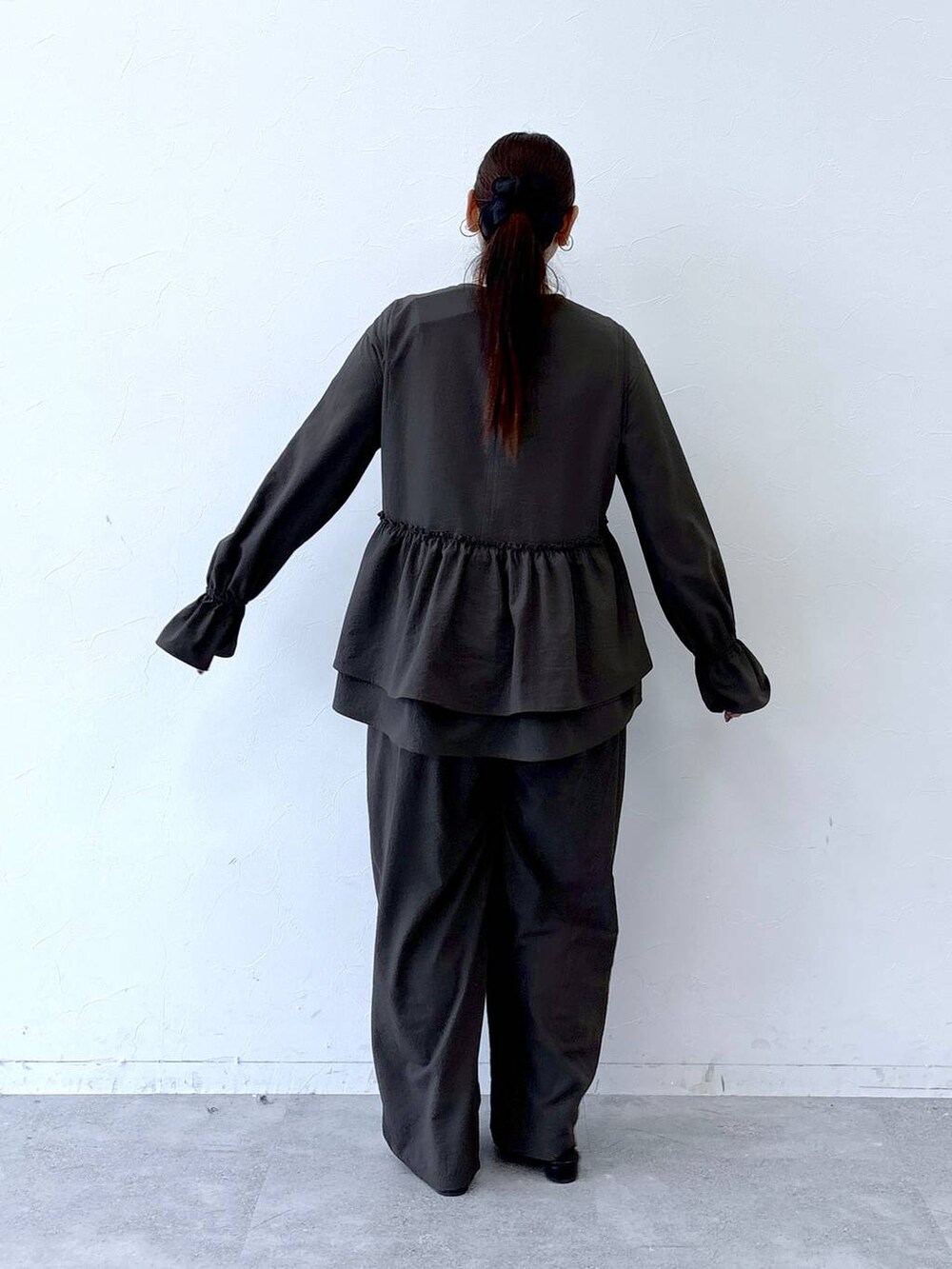 ブラック系のハンドバッグ、ブラック系のパンプス、ブラウン系のその他パンツを着用したレディースの冬コーディネートの4枚目の写真