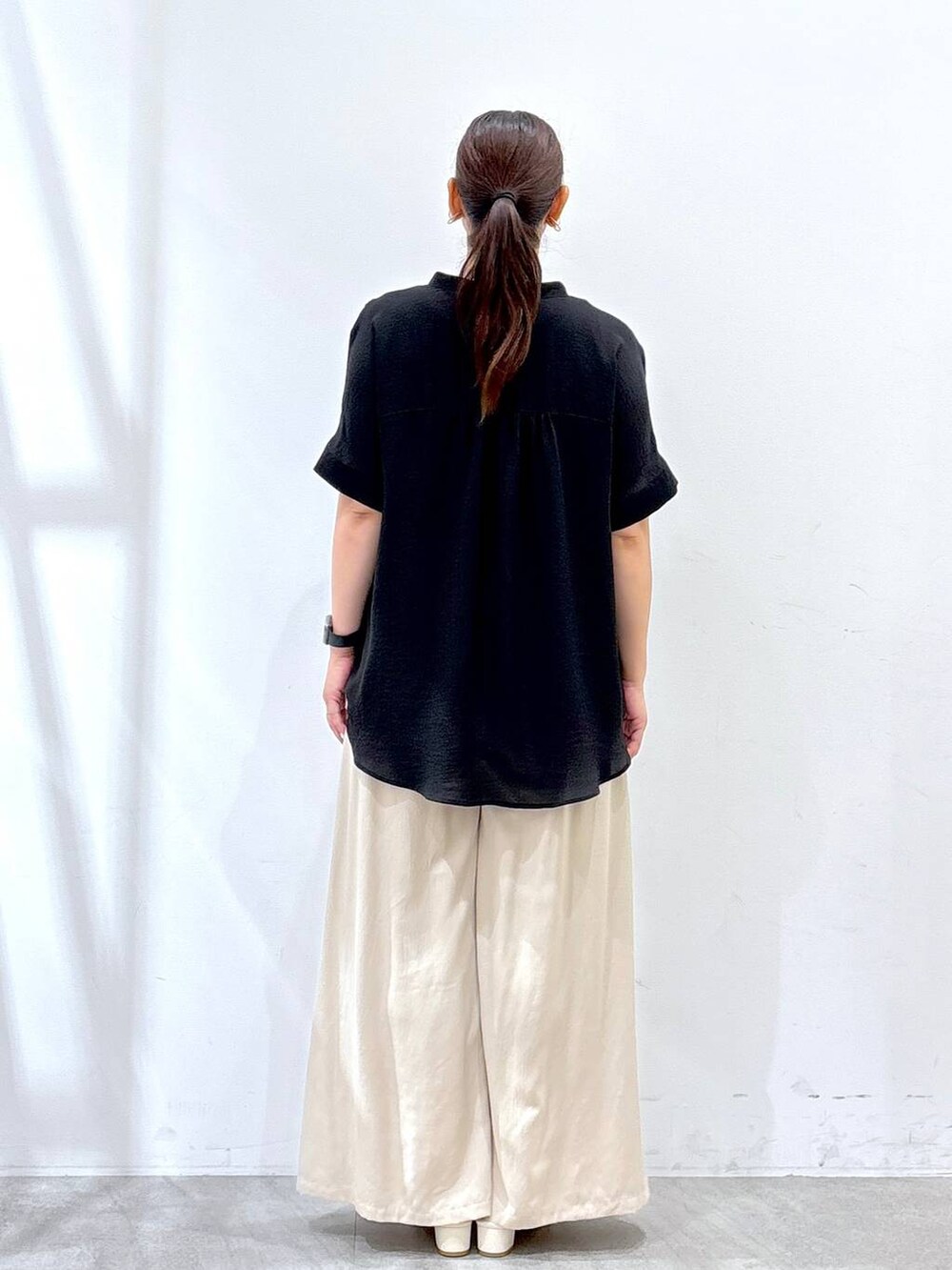 ベージュ系のその他パンツ、ブラック系のTシャツ/カットソーを着用したレディースの夏コーディネートの3枚目の写真